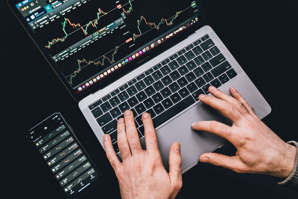 Manos usando un portatil con graficos de mercado