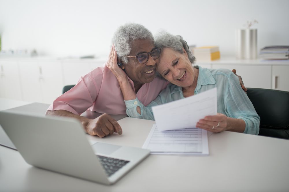 Pareja senior sonriendo mientras revisa un documento