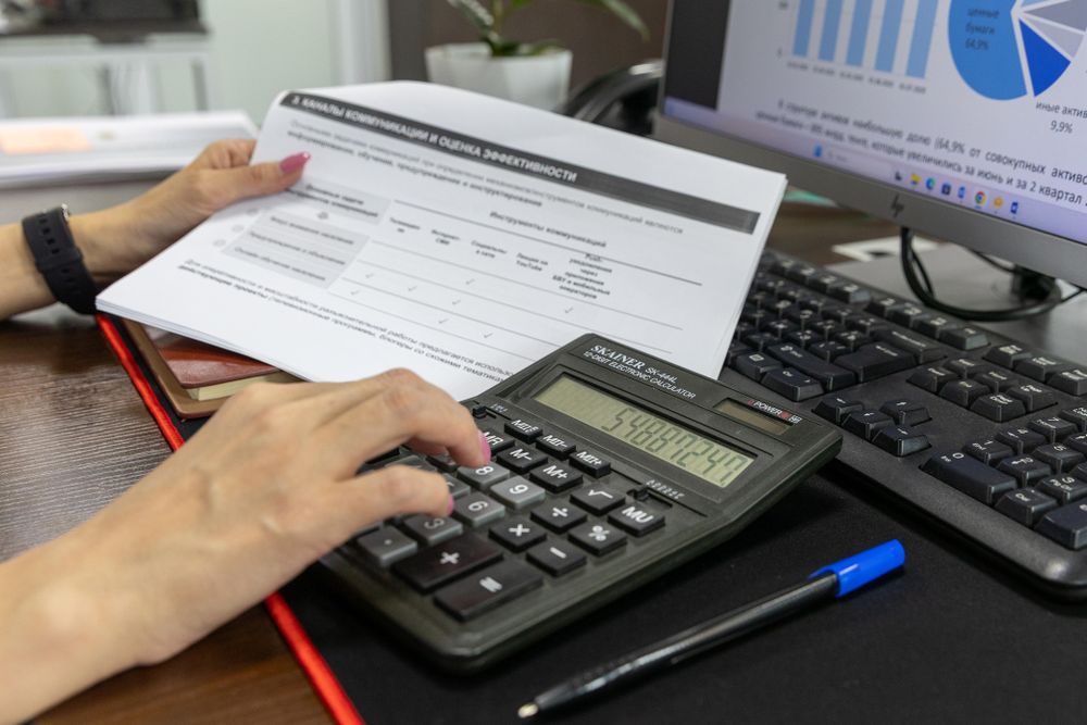 Analisis de documentos financieros con calculadora y boligrafo